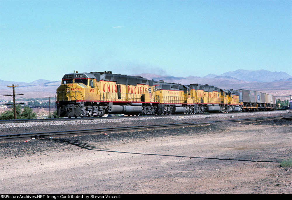 UP 6910 west with two Centennials and two Fast forties approaches East Barstow with it's caboose halfway to Nebo.